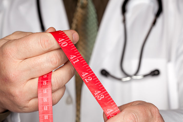 weight loss doctor with measuring tape